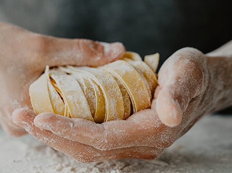 handmade pasta hands holding fresh pasta